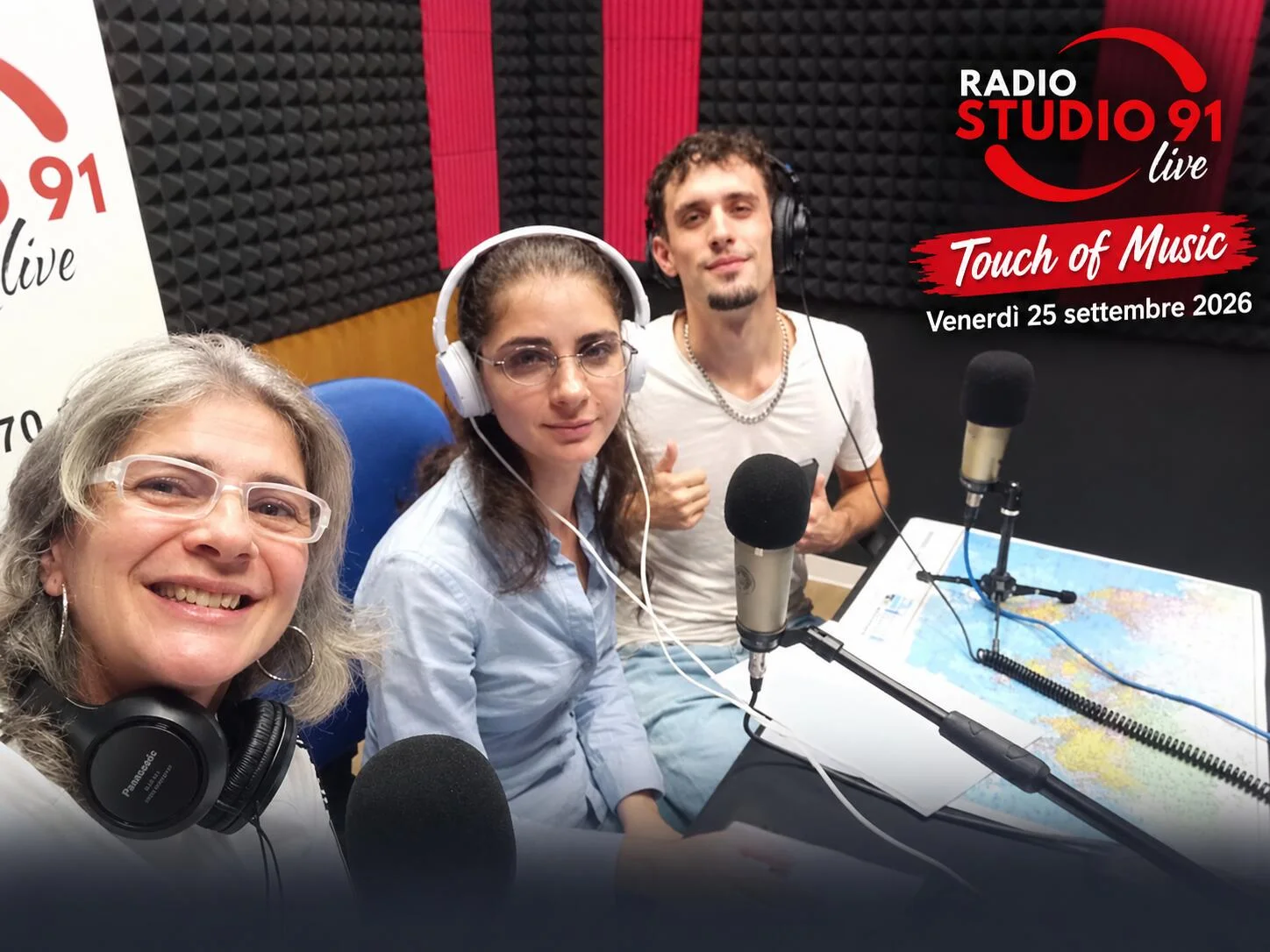 Tre organizzatori del festival con le cuffie, seduti davanti ai microfoni nello studio di Radio Studio 91 Live